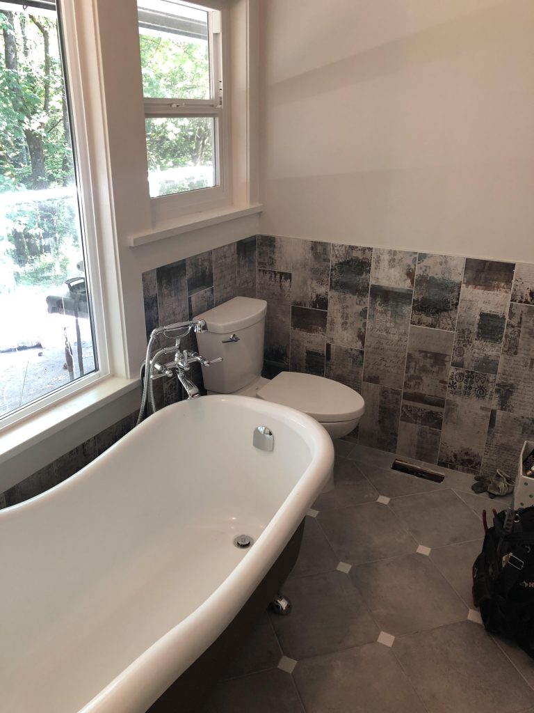 Renovated bathroom showing tub and toilet