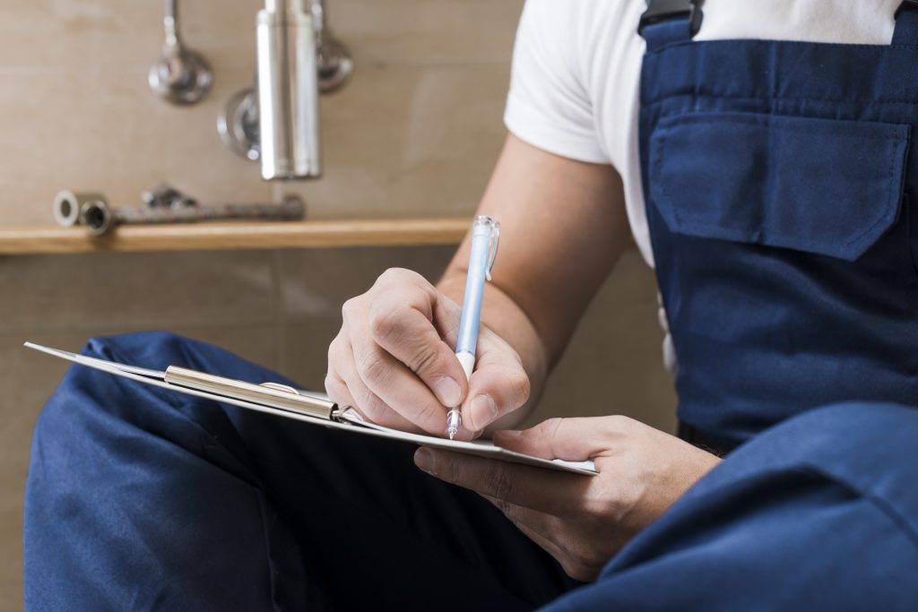 Commercial plumber sitting down taking notes